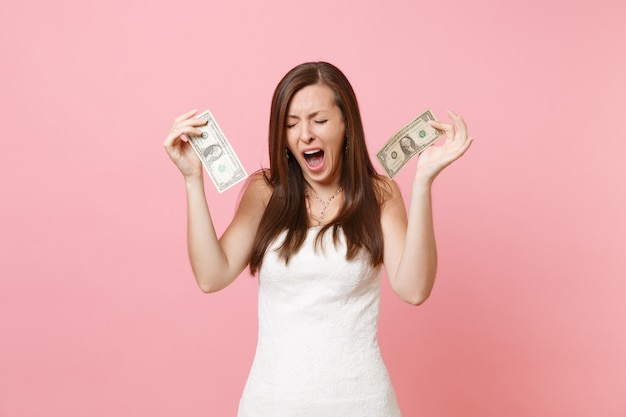 Porträt einer unzufriedenen Frau im weißen Kleid weinend mit einem Dollarschein holding