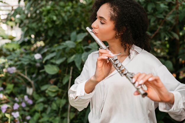 Foto porträt einer weiblichen musikerin, die ein blasinstrument für den weltmusiktag spielt