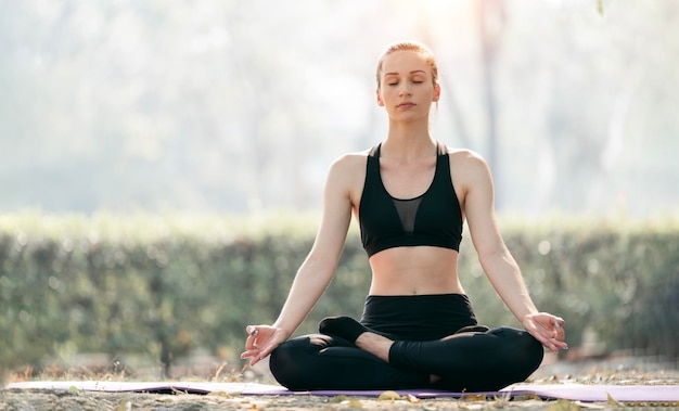 Porträt einer wunderschönen jungen Frau, die Yoga im Freien praktiziert, entspannen Sie sich in der Natur