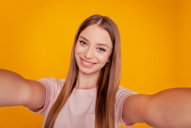 Porträt einer wunderschönen, positiven blonden Dame, die ein weißes Lächeln auf gelbem Hintergrund macht