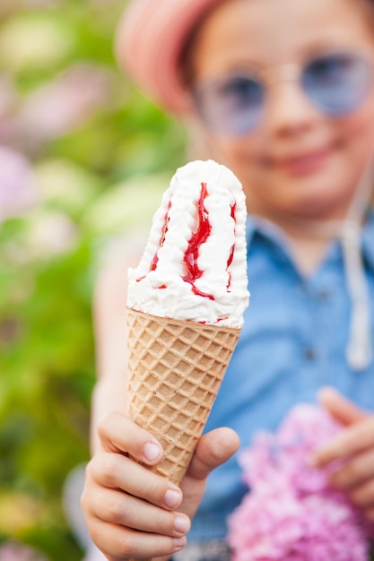 Porträt eines 7-jährigen Mädchens, das leckeres Eis isst.