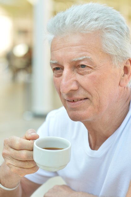 Porträt eines älteren Mannes, der eine Tasse Kaffee trinkt