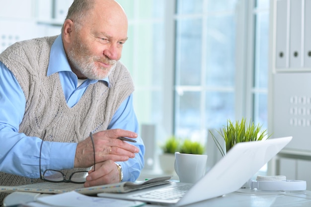 Porträt eines älteren Mannes mit Laptop