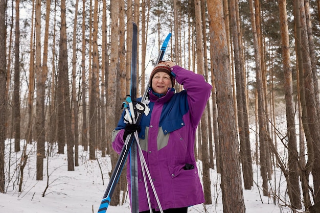 Porträt eines älteren Skifahrers in einem Winterwald