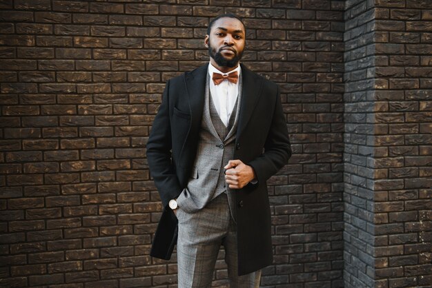 Porträt eines afroamerikanischen Geschäftsmannes, der einen Anzug trägt, der draußen steht