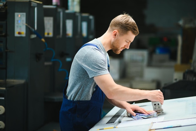 Porträt eines Arbeiters im Kontrollraum, der die Druckqualität in der Druckerei überprüft