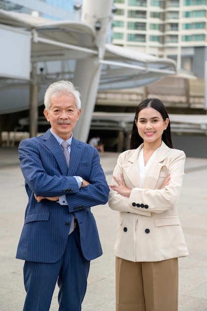 Porträt eines asiatischen, reifen Geschäftsmann mittleren Alters und einer jungen Geschäftsfrau in einer modernen Stadt