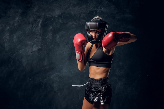 Porträt eines attraktiven Boxers mit Schutzhelm und kampfbereiten Handschuhen.