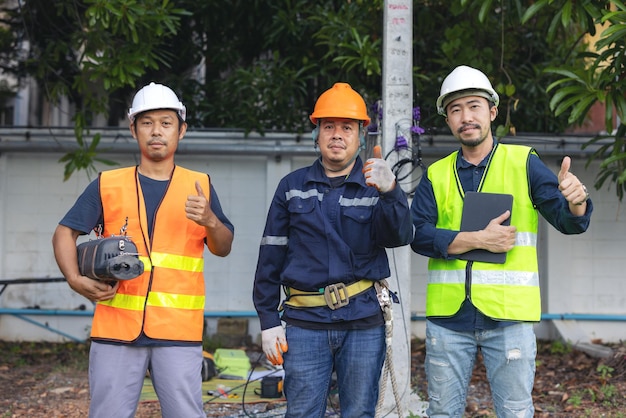 Porträt eines attraktiven elektrikers in uniform auf einer baustelle mit stromkabel für das netz elektrotechniker an einem kraftwerk