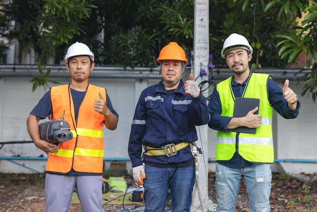 Porträt eines attraktiven Elektrikers in Uniform auf einer Baustelle mit Stromkabel für das Netz Elektrotechniker an einem Kraftwerk