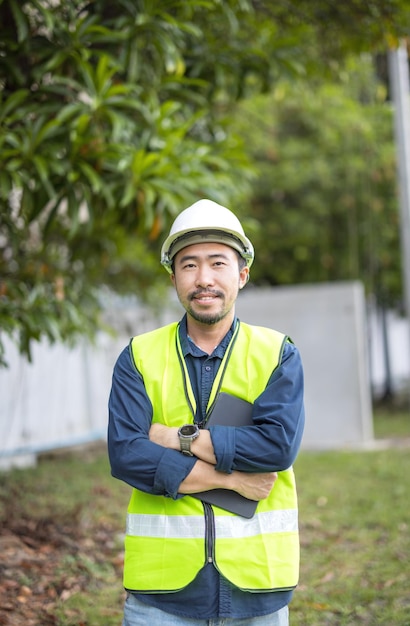 Porträt eines attraktiven Elektrikers in Uniform auf einer Baustelle mit Stromkabel für das Netz Elektrotechniker an einem Kraftwerk