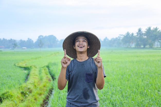 Porträt eines attraktiven, fröhlichen jungen asiatischen Bauern, der steht und einen Aha-Moment zeigt, der eine Idee bekommt