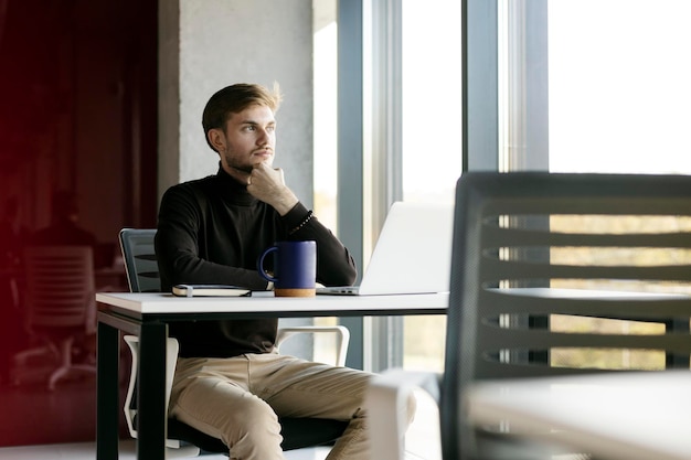 Porträt eines attraktiven Geschäftsmannes, der online arbeitet und wegschaut