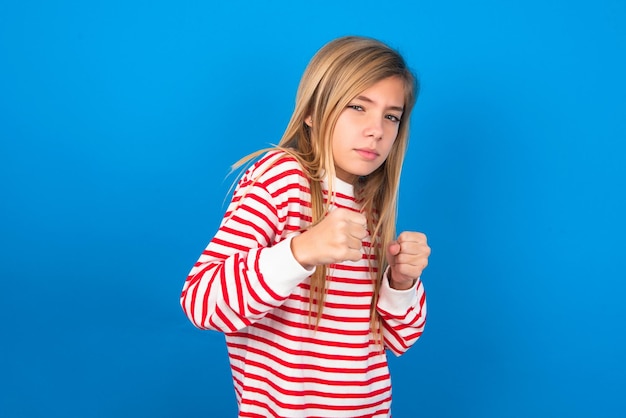 Foto porträt eines attraktiven teenager-mädchens, das sich in boxposition an den händen hält, um zu kämpfen