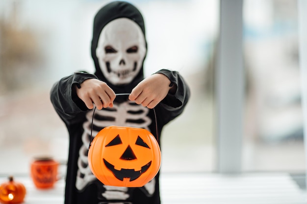 Porträt eines aufrichtigen, authentischen Gen Z-Jungen, der sich im Skelettkostüm an Halloween-Feiertagen amüsiert