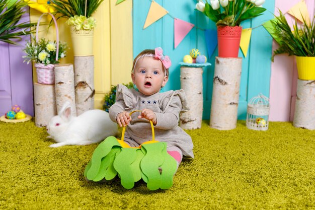 Porträt eines babys mit osterei. kleines mädchen auf ostereiersuche