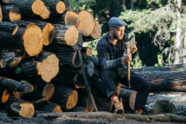 Porträt eines bärtigen brutalen Holzfällers, der Axt in der Hand hält