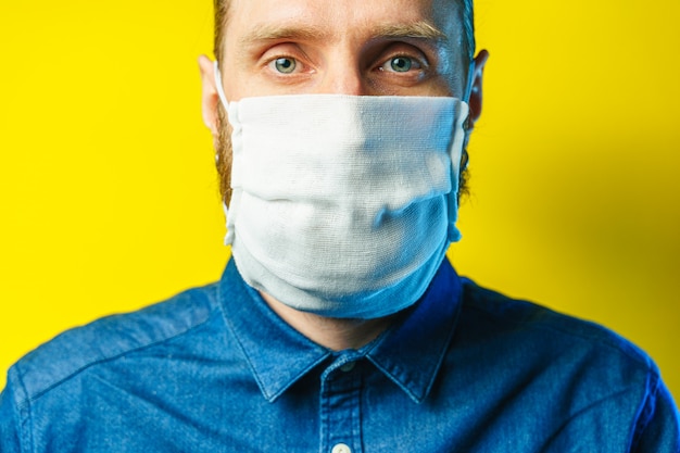 Porträt eines bärtigen Mannes in einer Mullmaske. Vorbeugender Schutz Ihrer eigenen Gesundheit vor Virusinfektionen. Coronavirus-Konzept.