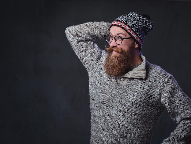 Porträt eines bärtigen rothaarigen Mannes mit Brille, gekleidet in einen Wollpullover und einen Hut.