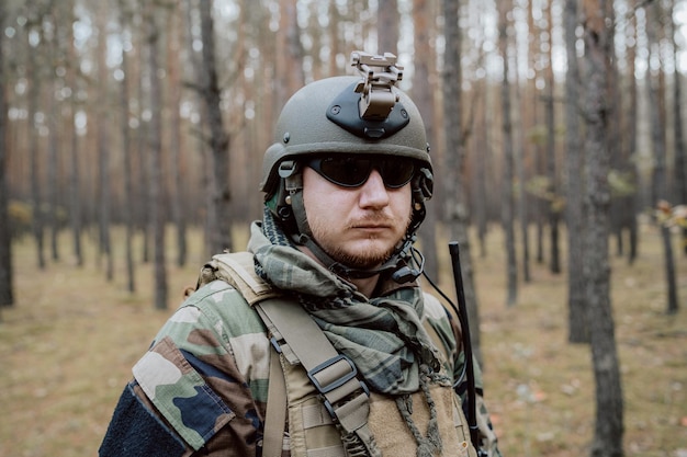 Porträt eines bärtigen Soldaten mittleren Alters in einer Waldmilitäruniform und einem Helm mit Kopfhörern