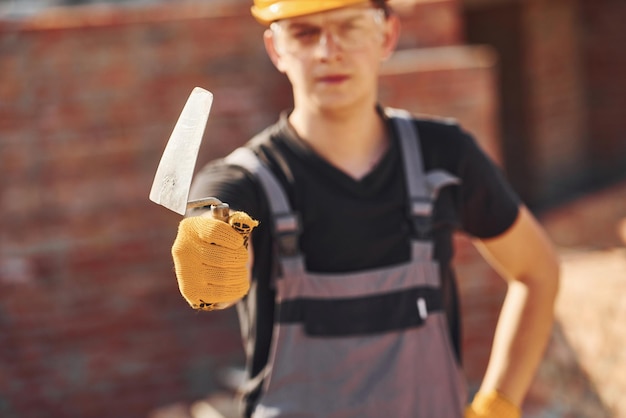 Porträt eines Bauarbeiters in Uniform und Sicherheitsausrüstung, der auf dem Gebäude steht