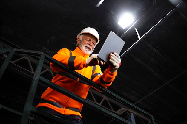 Porträt eines Bergmanns, der in einer unterirdischen Mine steht und die Erzproduktion überprüft