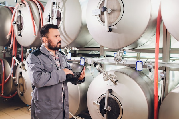 Porträt eines Brauers, der an seinem Arbeitsplatz im Sudhaus Bier macht.