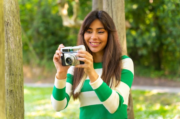 Porträt eines brünetten kaukasischen Mädchens im Urlaub in der Natur, das Fotos mit der Kamera macht