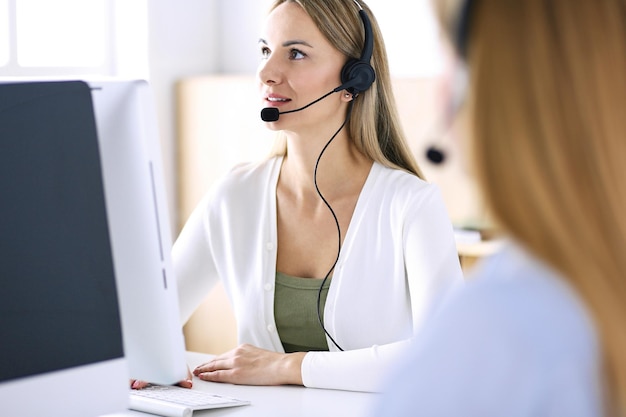 Porträt eines Call-Center-Betreibers bei der Arbeit. Gruppe von Personen in einem Headset, die bereit sind, Kunden zu helfen. Unternehmenskonzept.