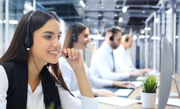 Porträt eines Call-Center-Mitarbeiters in Begleitung seines Teams Lächelnder Kundendienstmitarbeiter bei der Arbeit