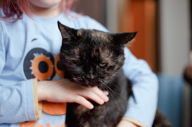 Porträt eines entzückenden kaukasischen Mädchens, das eine süße schwarze Katze hält.Haustierkonzept.Lifestyle-Fotografie zu Hause