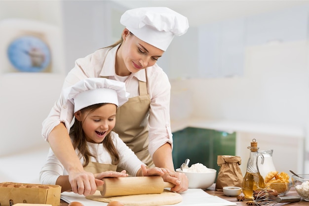 Porträt eines entzückenden kleinen Mädchens und ihrer Mutter, die zusammen backen