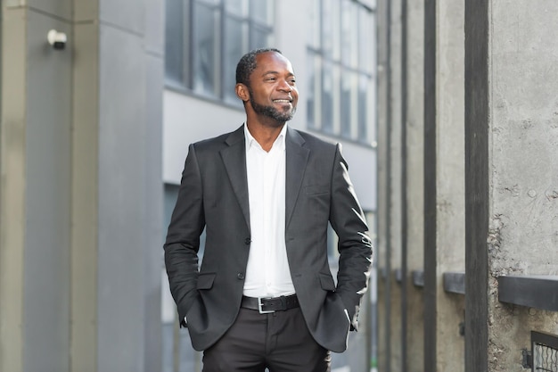 Porträt eines erfolgreichen afroamerikanischen Geschäftsmanns, Anwaltsbanker, der in der Nähe eines Unternehmens steht