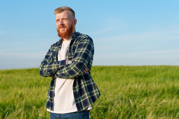 Porträt eines erfolgreichen Landwirts Ein Mann steht in Hemd und Jeans in einem Weizenfeld