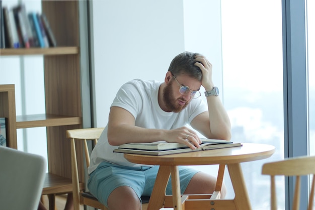 Porträt eines ernsthaften, konzentrierten jungen Mannes mit Brille, der studiert