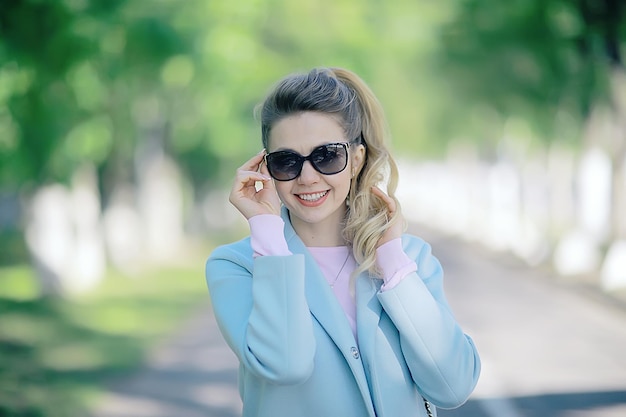 Porträt eines europäischen schönen weiblichen Modells mit Sonnenbrille / Mädchen im Freien zu Fuß, fröhliches, fröhliches Mädchen mit Brille