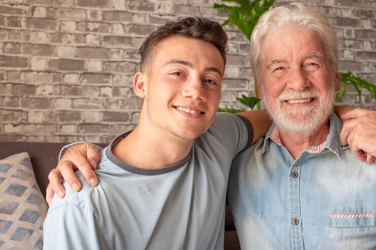Porträt eines Familienpaares, eines kleinen Jungen und seines alten Großvaters, der lächelnd in die Kamera blickt