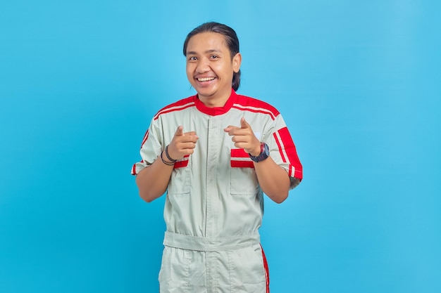 Porträt eines fröhlichen gutaussehenden Mannes in mechanischer Uniform, der mit den Fingern auf die Kamera zeigt