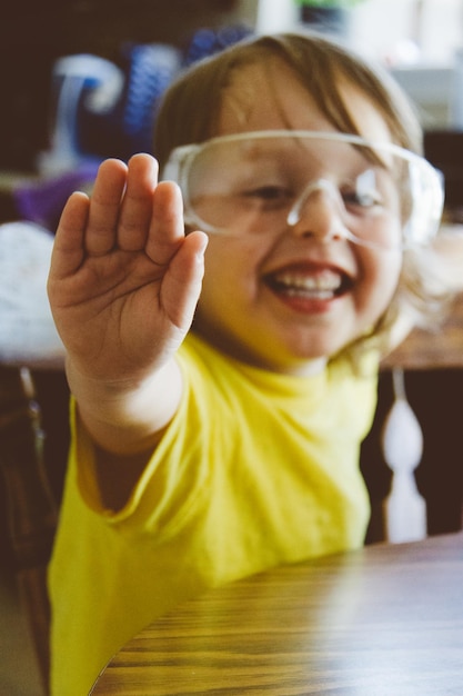 Foto porträt eines fröhlichen jungen, der an einem tisch gespielt