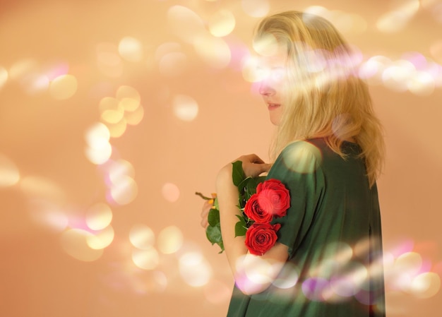 Porträt eines fröhlichen jungen Mädchens im Kleid mit roten Rosen