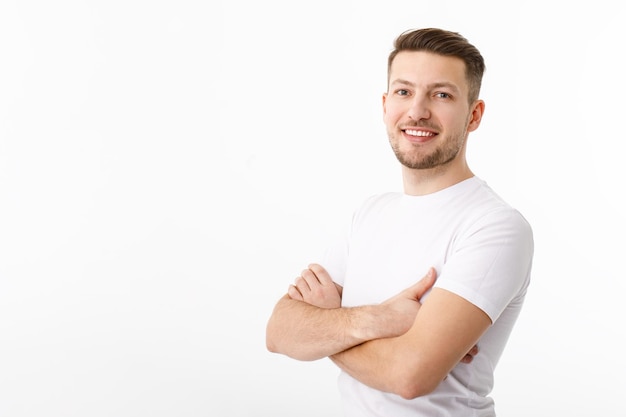 Porträt eines fröhlichen jungen Mannes in einem weißen T-Shirt auf weißem Hintergrund Der Mann steht, schaut in die Kamera und lächelt