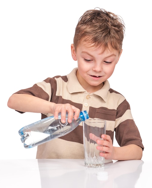 Porträt eines fröhlichen kleinen Jungen mit Glas und Plastikflasche Wasser Schöne lächelnde Kind trinkt Wasser isoliert auf weißem Hintergrund