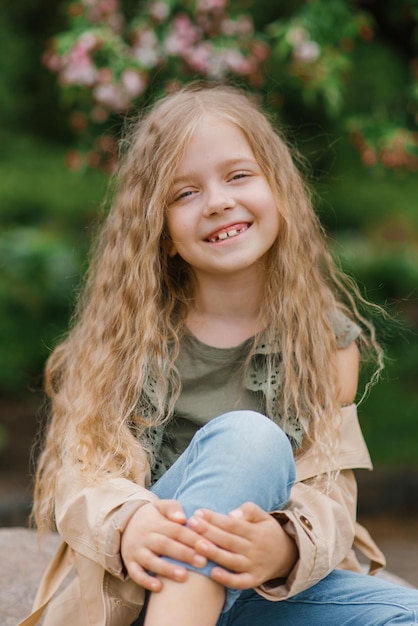 Porträt eines glücklich lächelnden siebenjährigen Mädchens mit langen braunen Haaren