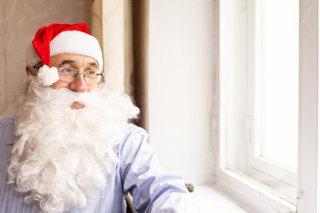 Porträt eines glücklichen älteren Mannes in Weihnachtsmütze, der sich auf Weihnachten vorbereitet