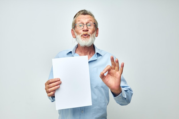 Porträt eines glücklichen älteren Mannes, leeres Blatt Papier, Geste, Hände, Lächeln, beschnittene Ansicht