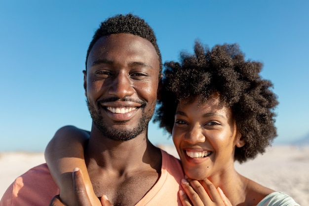 Porträt eines glücklichen afroamerikanischen Paares, das den Sommerurlaub am Strand genießt