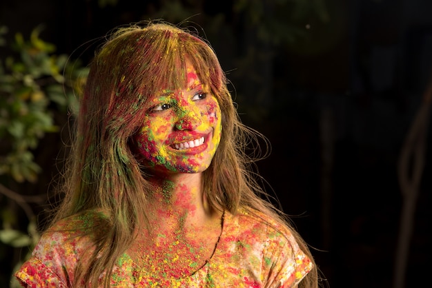 Porträt eines glücklichen jungen Mädchens auf dem Fest der Farben Holi. Mädchen, das das Fest der Farben aufwirft und feiert.