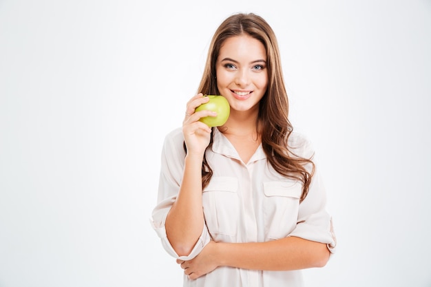 Porträt eines glücklichen jungen Mädchens mit grünem Apfel isoliert auf einer weißen Wand