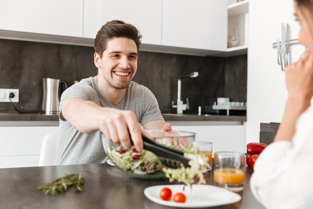 Porträt eines glücklichen jungen Mannes, der gesundes Frühstück hat