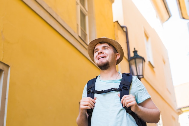 Foto porträt eines glücklichen jungen mannes, der mit rucksack reist, hautnah.